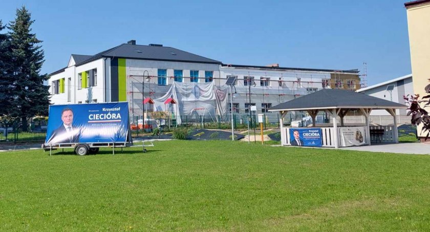 Bannery Krzysztofa Ciecióry obok sąsiadującej szkoły w Kietlinie