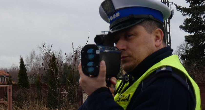 Na zdjęciu policjant mierzący prędkość pojazdów
