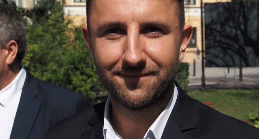 Na zdjęciu Patryk Marjan podczas konferencji na placu 3 Maja