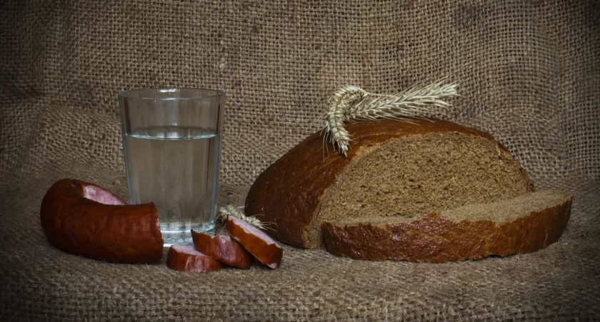Na zdjęciu chleb, kiełbasa i alkohol
