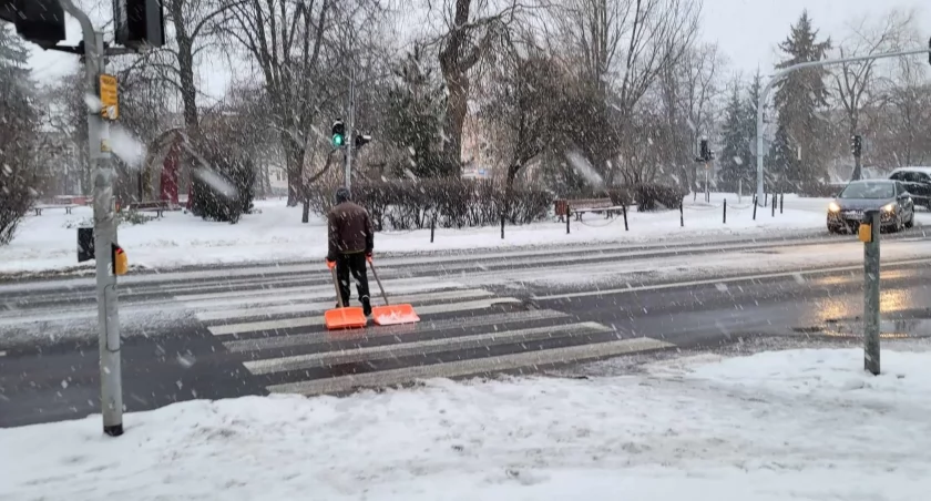 Na zdjęciu mężczyzna z łopatami do odśnieżania