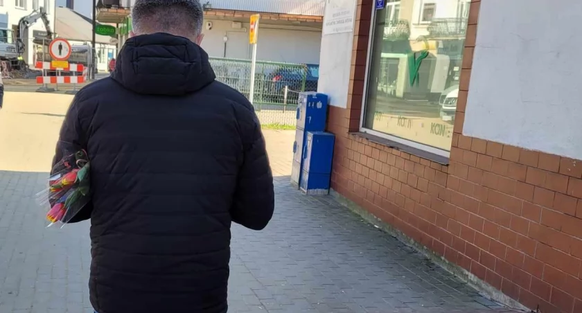 Na zdjęciu mężczyzna z kwiatami