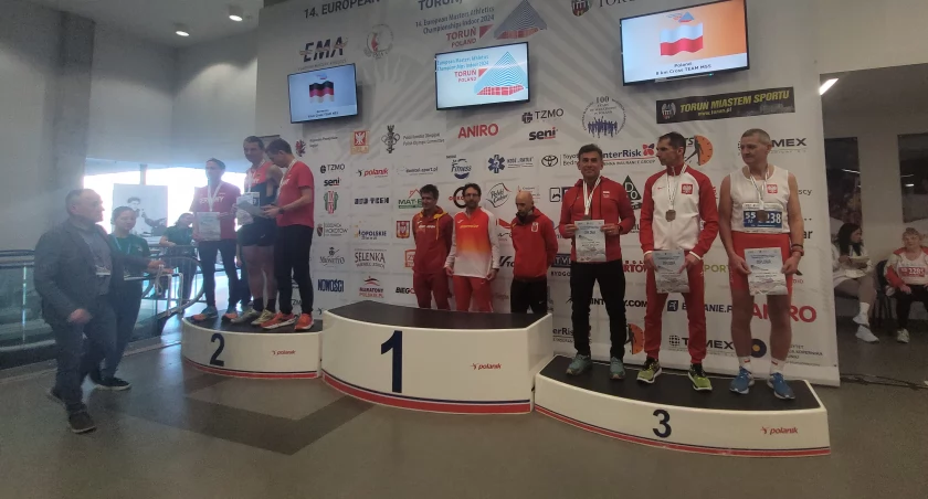 Na zdjęciu pan Piotr na najniższym stopniu podium