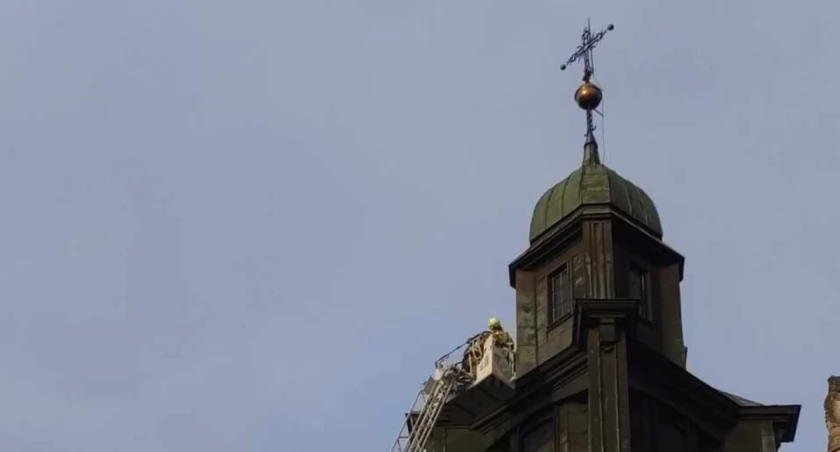 Na zdjęciu strażak zabezpieczający krzyż, fot. Morawiec