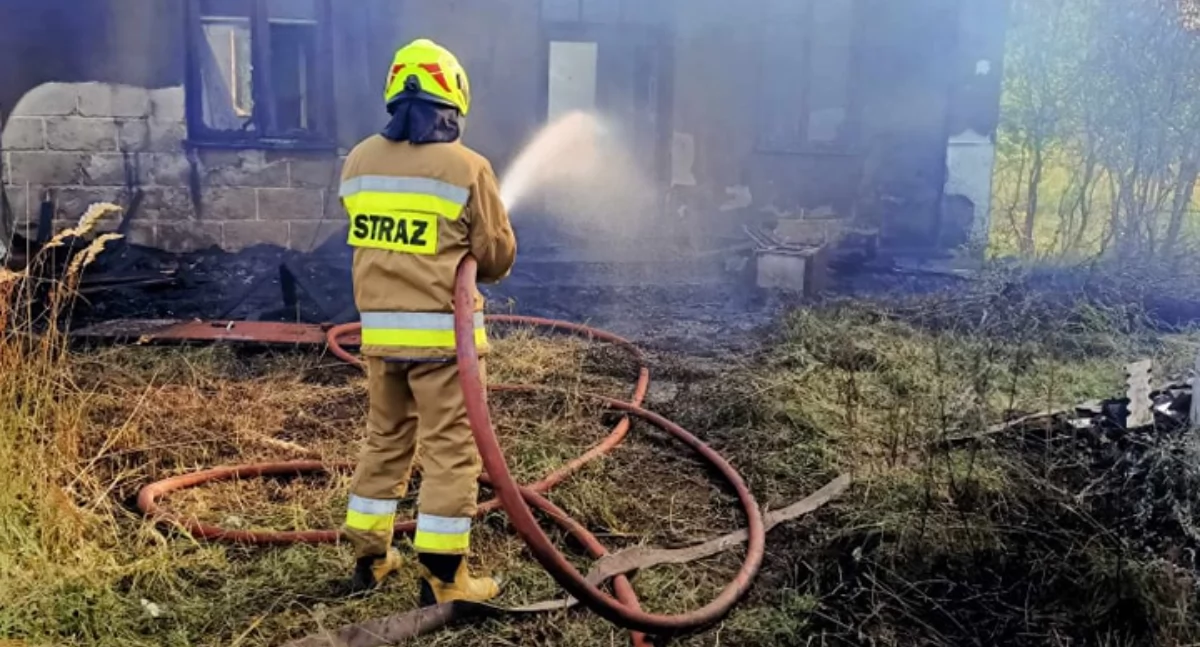 Na zdjęciu: Strażak gaszący pożar w Koźniewicach, fot. Facebook/OSP Kamieńsk