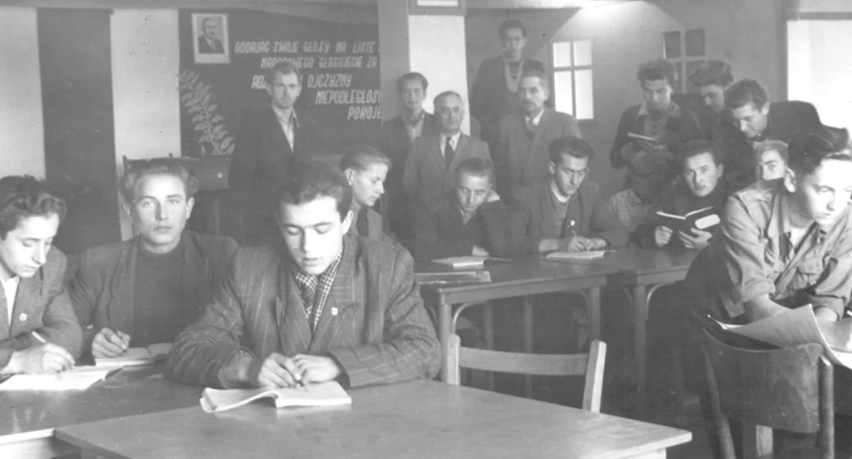 Na zdjęciu: Uczniowie Technikum Mechanicznego w sali lekcyjnej z nauczycielami. Na ścianie portret B. Bieruta wskazuje na lata 40.-50. XX wieku. Zbiory muzeum
