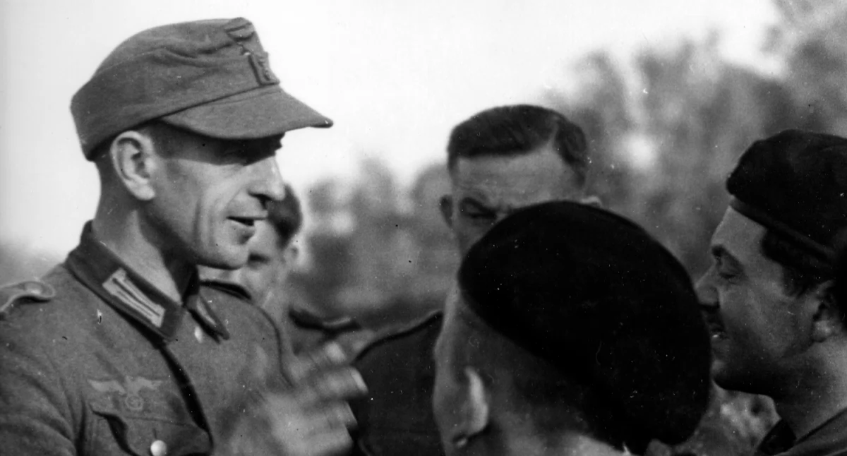 Na zdjęciu: l Przymusowo wcielony do Wehrmachtu Polak rozmawia z żołnierzami 1 Dywizji  Pancernej gen. Stanisława Maczka, fot. Wikipedia