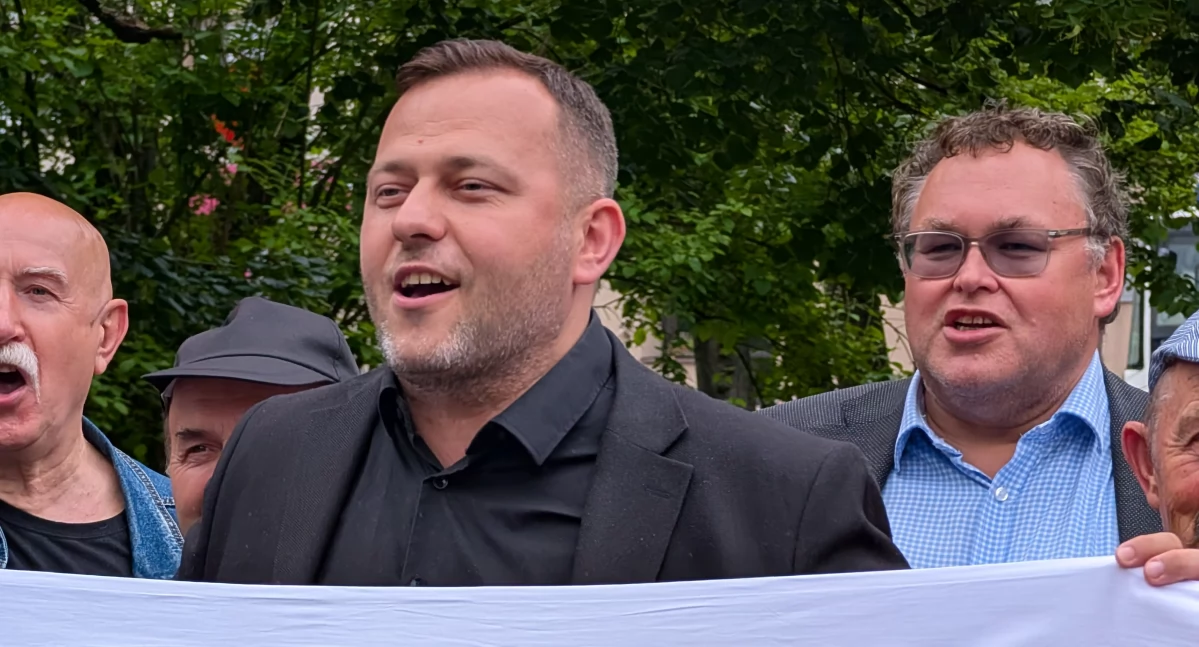 Na zdjęciu: Michał Koski na wiecu przed wyborami prezydenckimi, z transparentem „ByleNieTrzaskowski”. Z tyłu radny Szymon Zyberyng