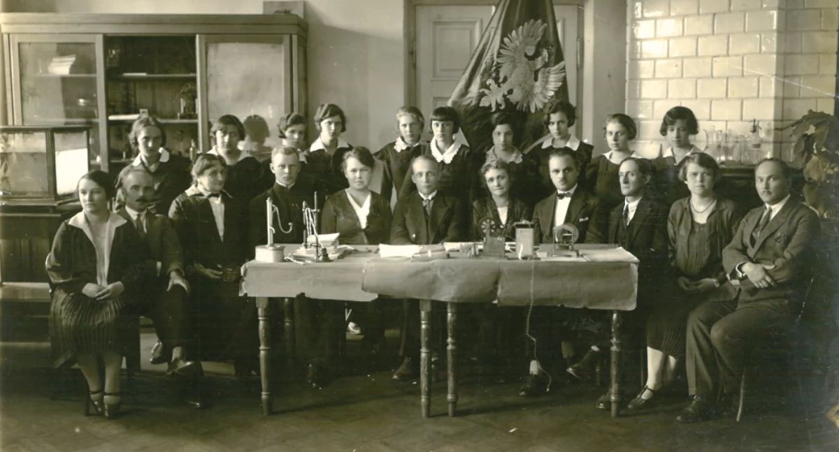 Na zdjęciu: Uczennice i kadra na tle  sztandaru: od lewej Kierocińska, inż. Górski (?), Siwadłowska, ks. Zawadzki, J. Chomicz, Kucharski - polonista, 3 z prawej Pilny  - botanik, M. Chomicz - druga z prawej, 1928/1929 (?)