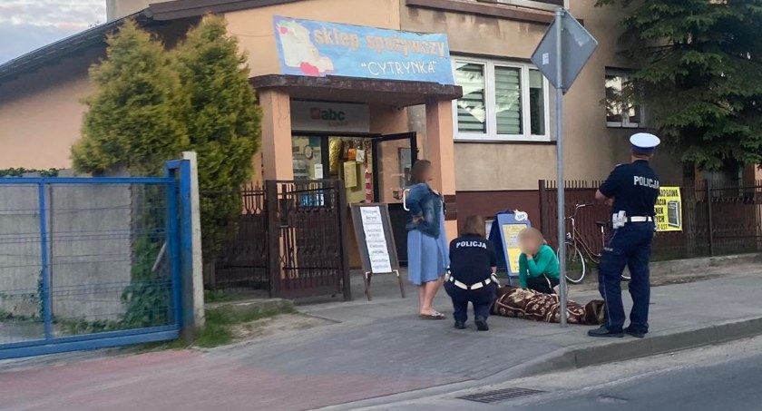 Na zdjęciu - rowerzystka, która wjechała w znak, czeka na pomoc medyczną