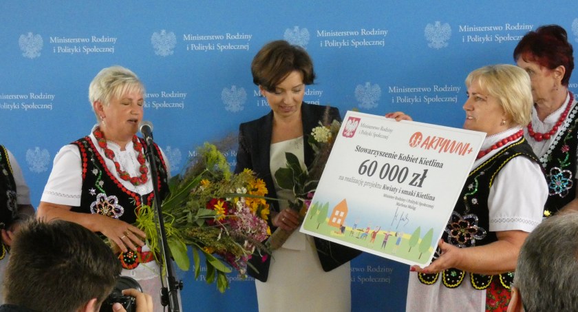 Na zdjęciu w środku minister Marlena Maląg przekazuje kobietom z KGW w Kietlinie w spracie na kolejny ich projekt