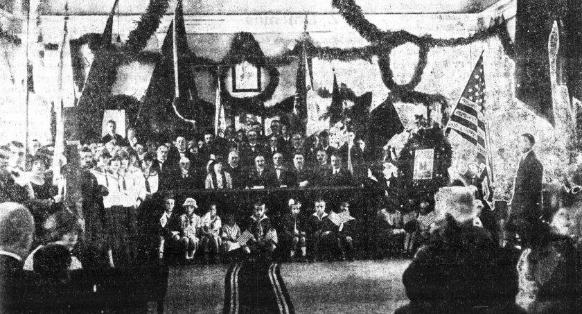Na zdjęciu uczestnicy uroczystej Akademii w ratuszu miejskim, po prawej portret prezydenta Wilsona oraz polskie i amerykańskie sztandary. Fot. L. Wajnberg, „Gazeta Radomskowska” 1926, nr 29