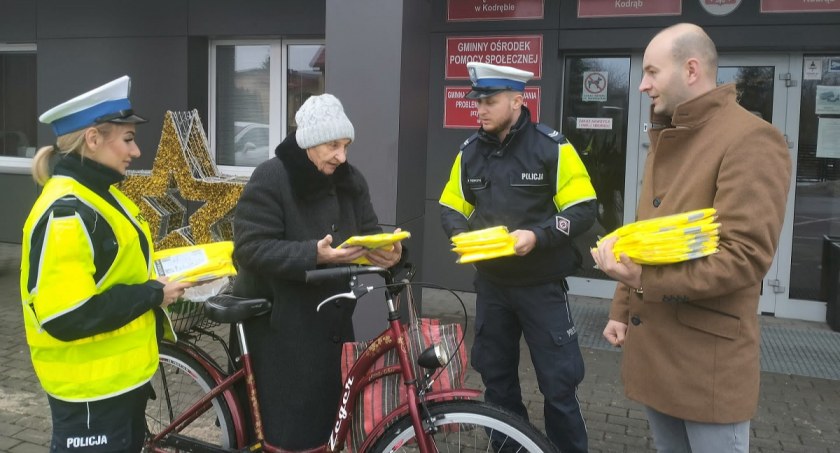 Na zdjęciu policjanci wręczają kamizelkę odblaskową mieszkance Kodręba - fot. KPP Radomsko