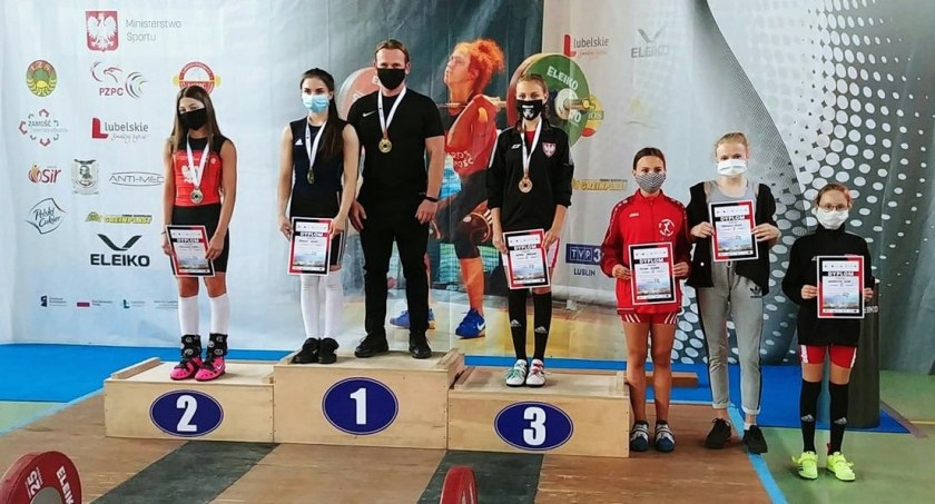 Na zdjęciu sztangistki na podium, I miejsce Oliwia Drzazga, obok trener Sebastian Bera