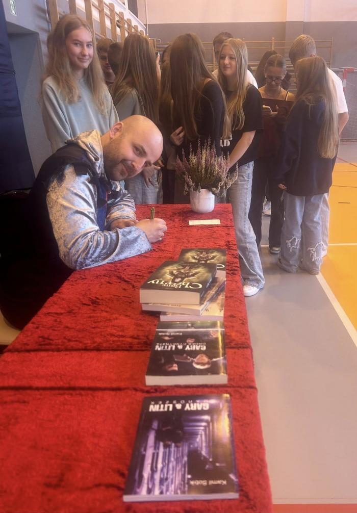 Kamil Sobik pisarz podpisuje książki w szkole w Kobielach Wielkich